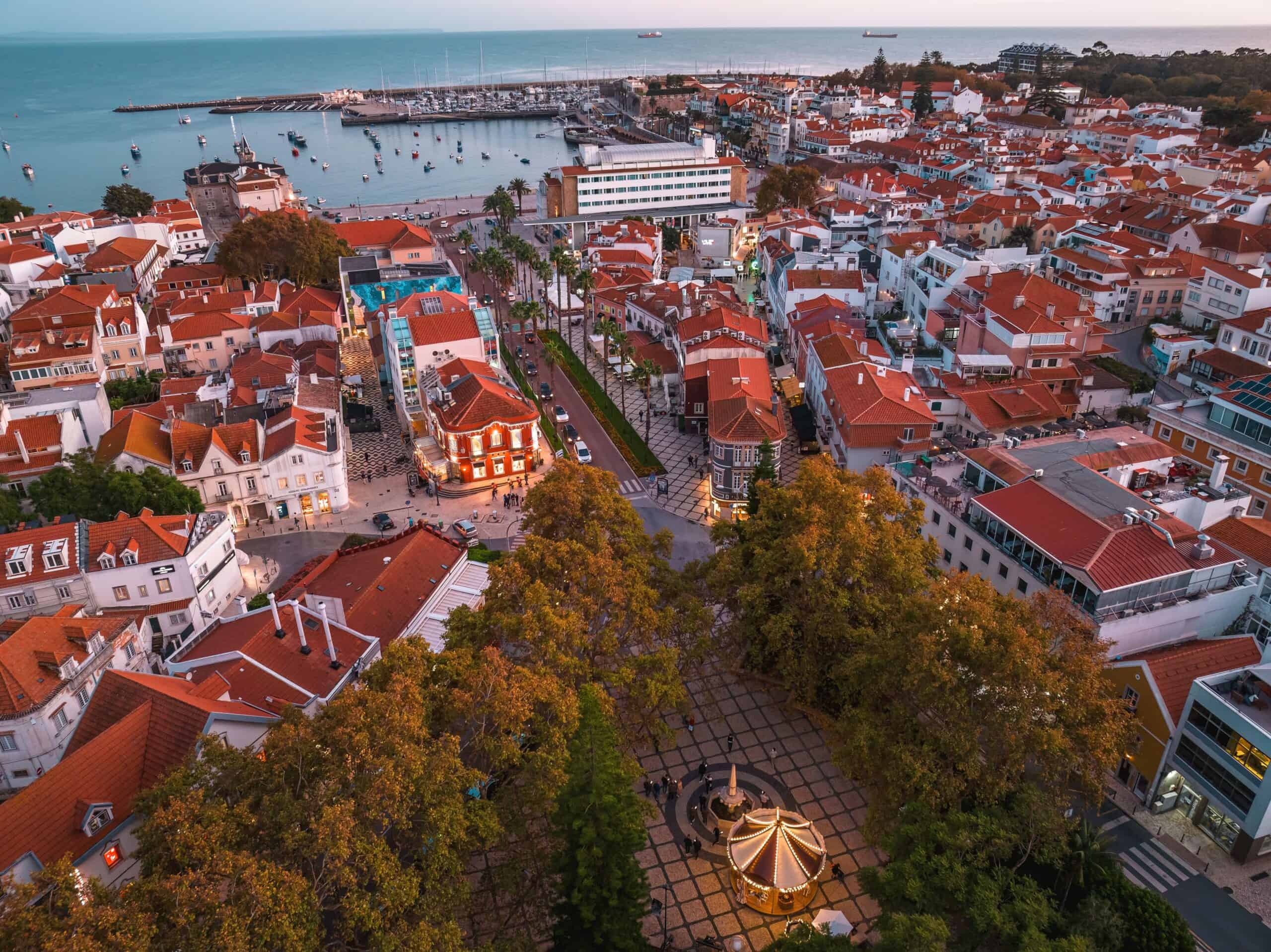 Praia da Rainha con aguas turquesas y el casco antiguo de Cascais al fondo