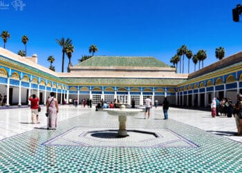 Patio del Palacio de la Bahía con fuente y visitantes en Marrakech.