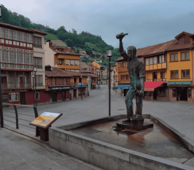 Fuente de bronce en la plaza principal de Potes, Cantabria, con edificios tradicionales.