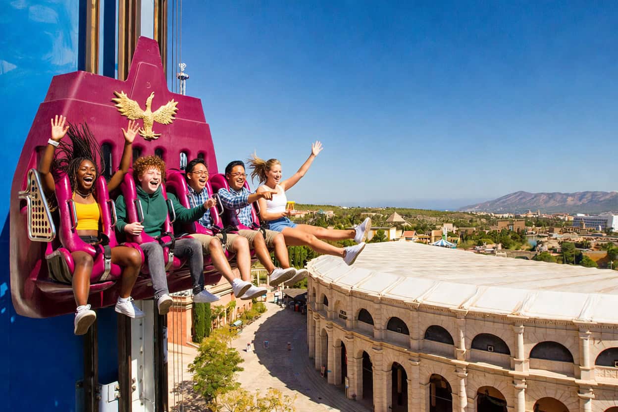 Grupo de amigos disfrutando en una atracción de parque temático en España.