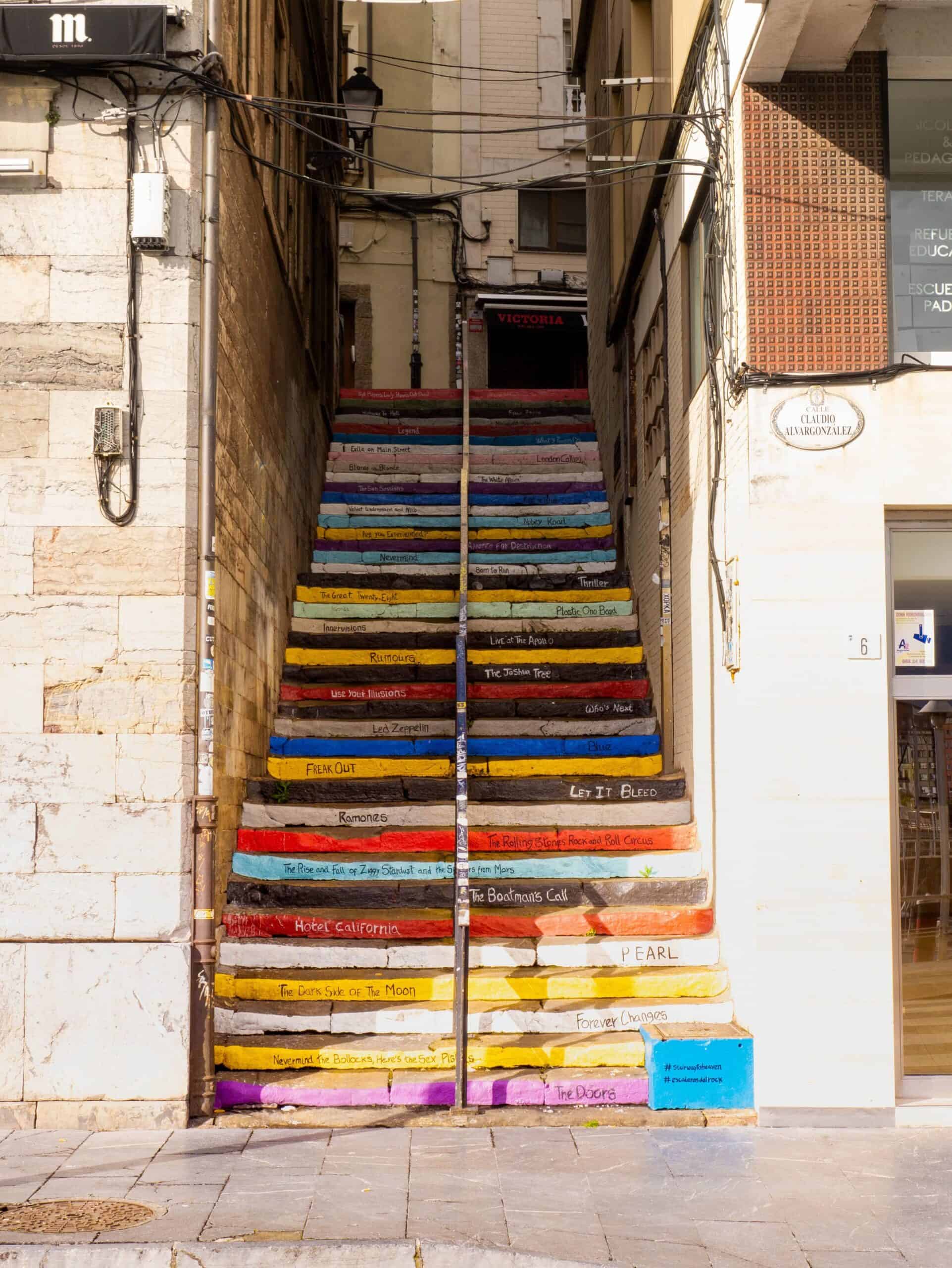 Escaleras pintadas con colores vibrantes en un callejón urbano.