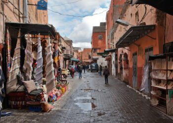 Vista de una calle tradicional en Marruecos con puestos de artesanías y edificios antiguos.